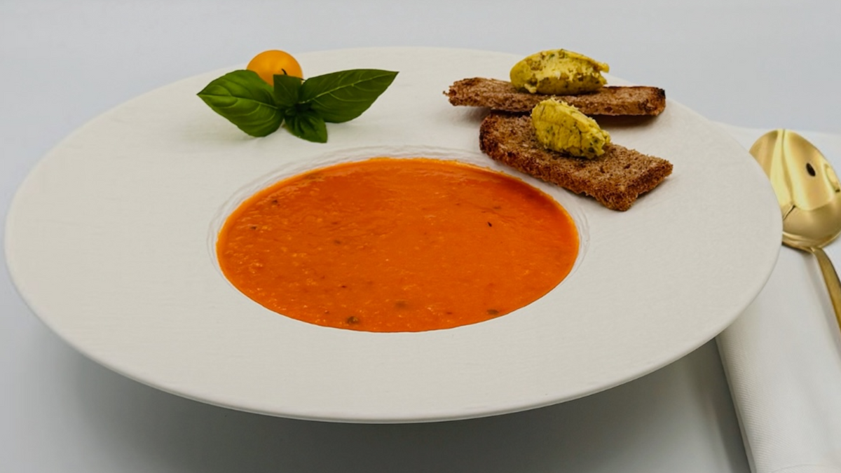 Cremige Tomaten-Suppe mit frischen Tomaten, Basilikum, Olivenöl und geröstetem Brot mit Café-de-Paris-Butter 